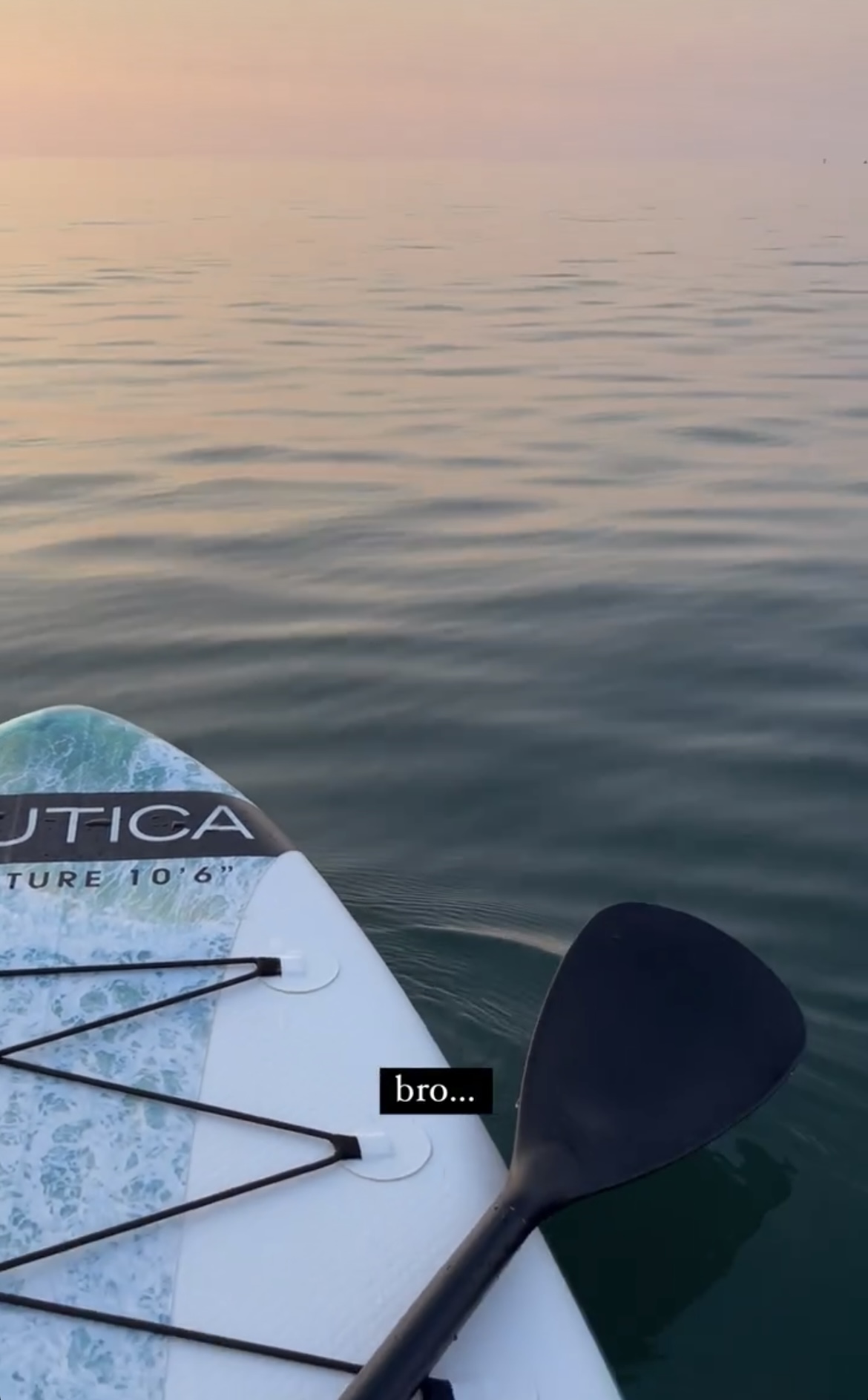 Paddleboard and paddle on the Black Sea at sunset